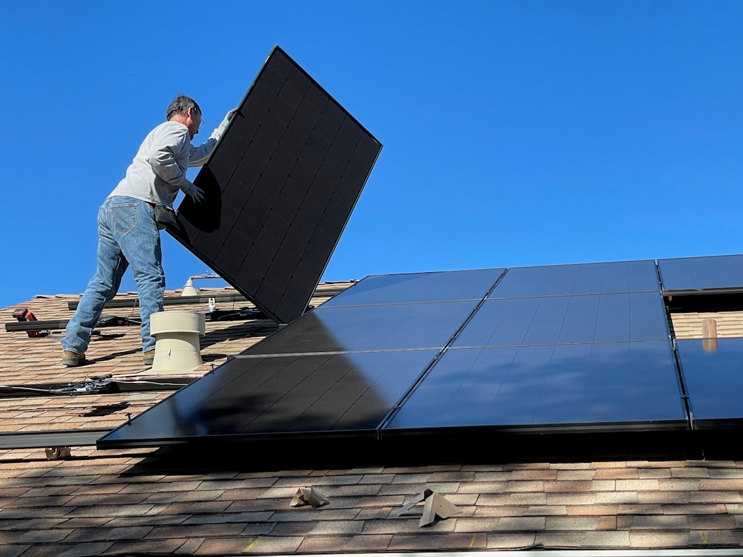 About Worker installing solar panels on a roof